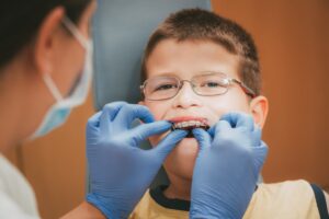 Boy with braces undergoing dental examination and treatment.
